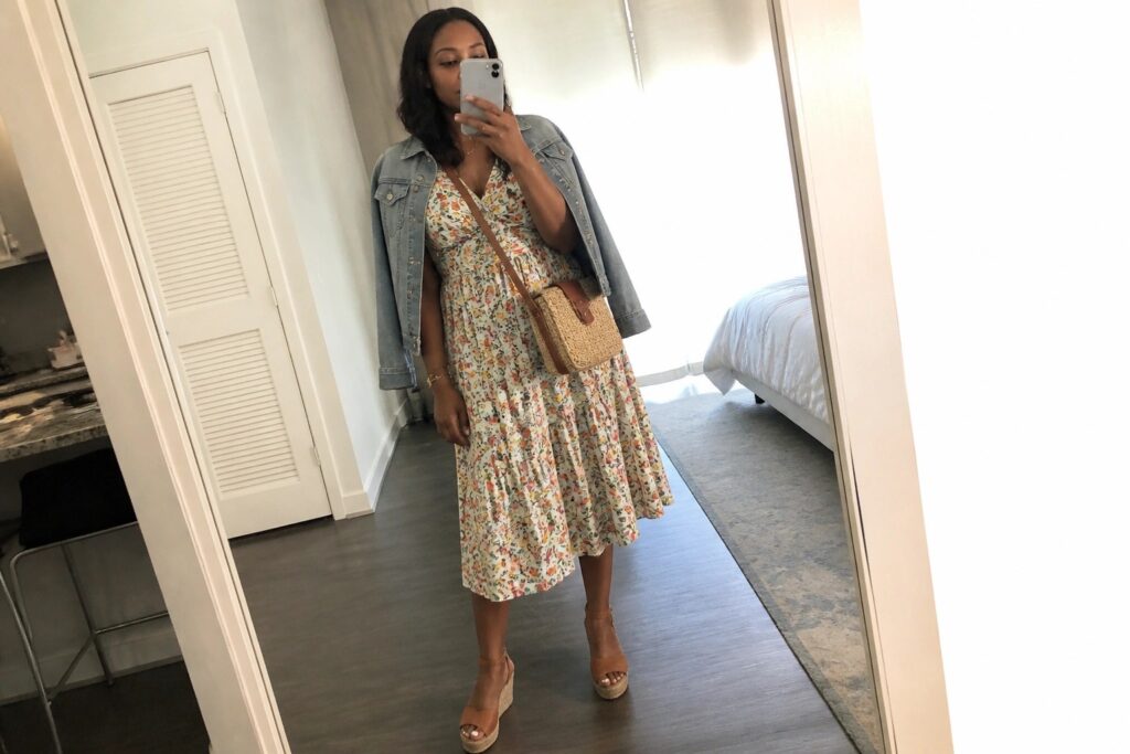 19 Brunch Outfits for Black Women Perfect for Weekend Plans Woman in floral dress and denim jacket taking mirror selfie in apartment
