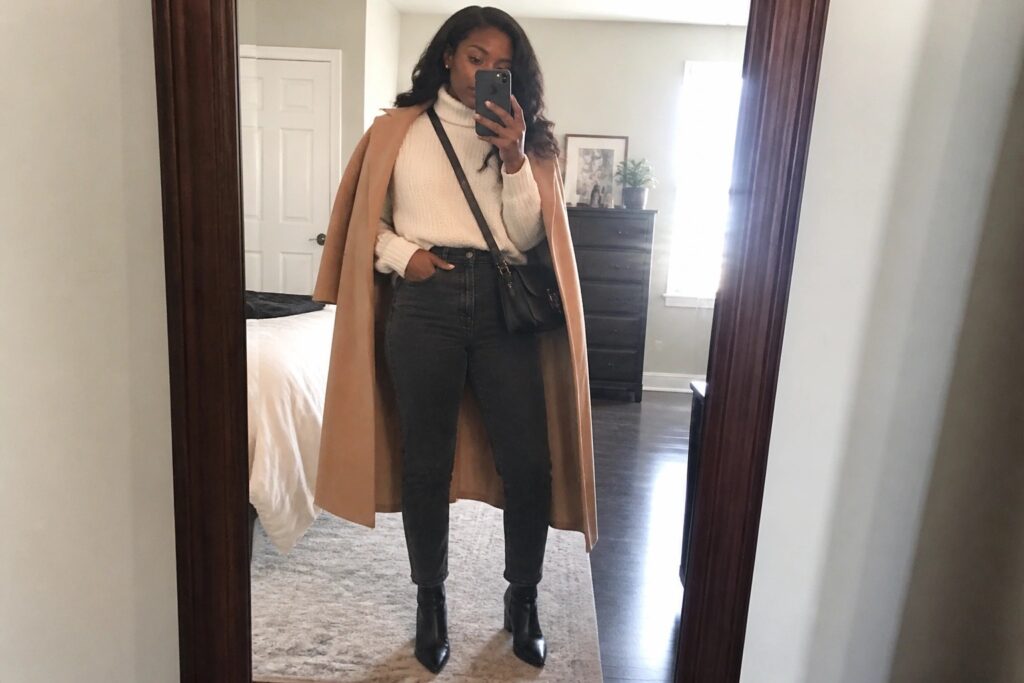 19 Chic Winter Outfits for Black Women Designed for Cold Weather Style Woman in tan coat and cream turtleneck taking mirror selfie in bedroom