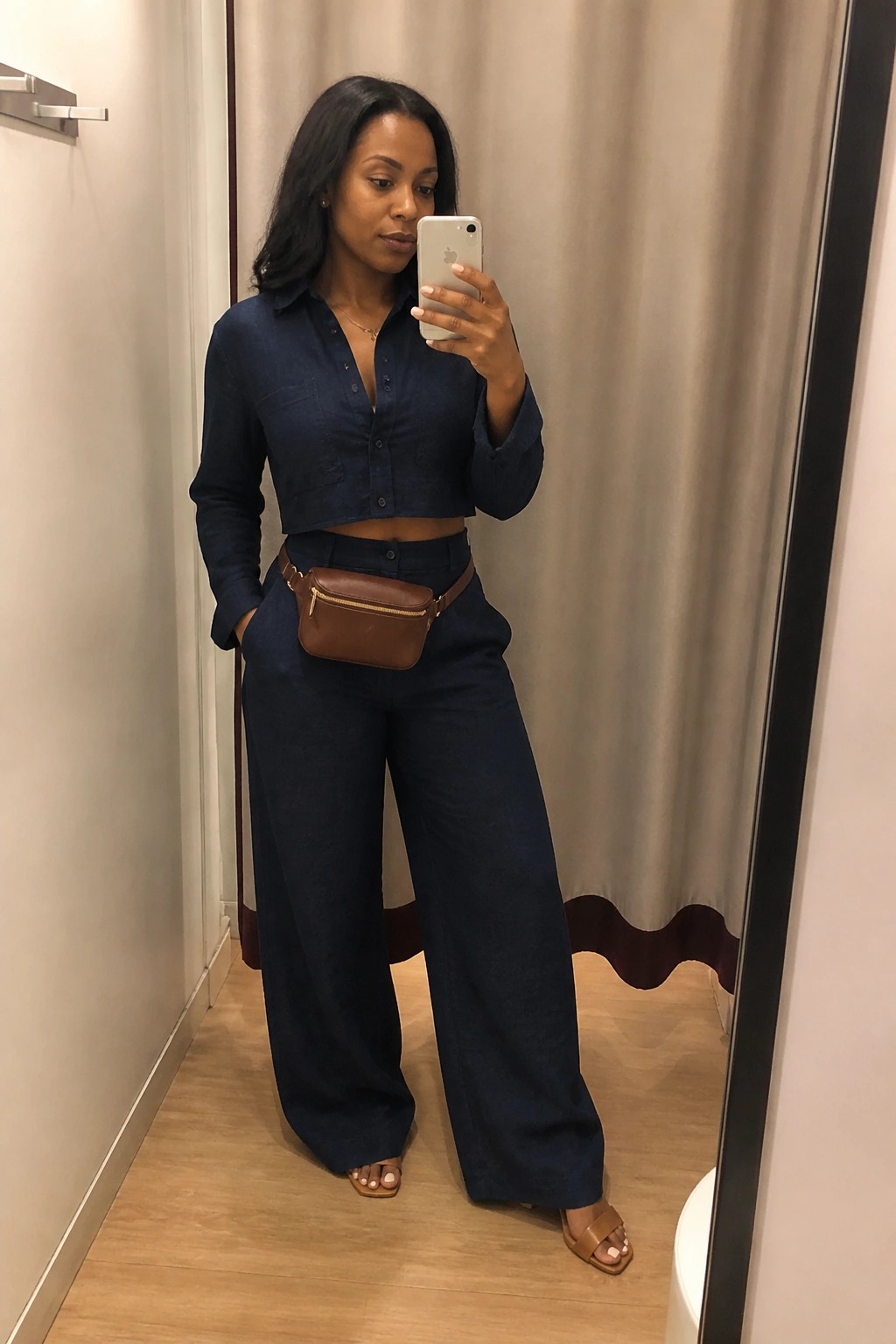 Woman taking mirror selfie in navy blue cropped denim shirt and wide pants