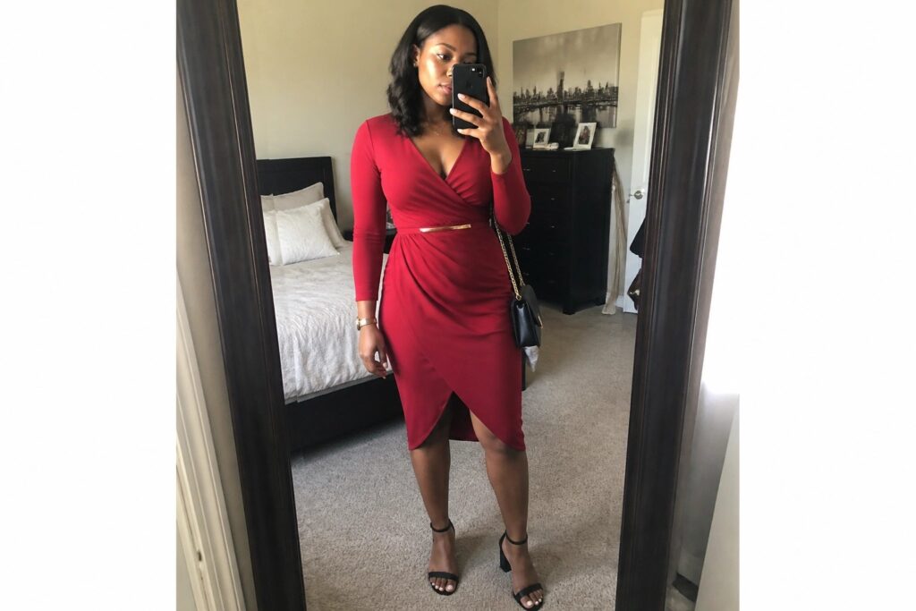 18 Chic Red Outfits for Black Women Featuring Dresses, Sets, and Statement Pieces Woman in red wrap dress taking mirror selfie in bedroom with gold belt