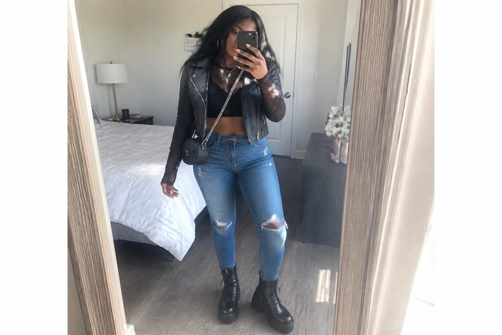 20 Stylish Club Outfits for Black Women in Edgy Street Style Woman in black leather jacket, mesh top, ripped jeans, and combat boots posing