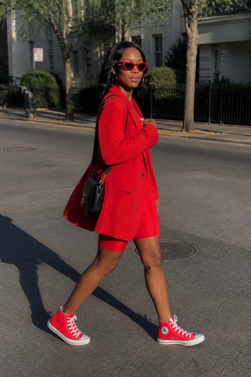 Woman in red blazer and shorts with red high-top sneakers on city street