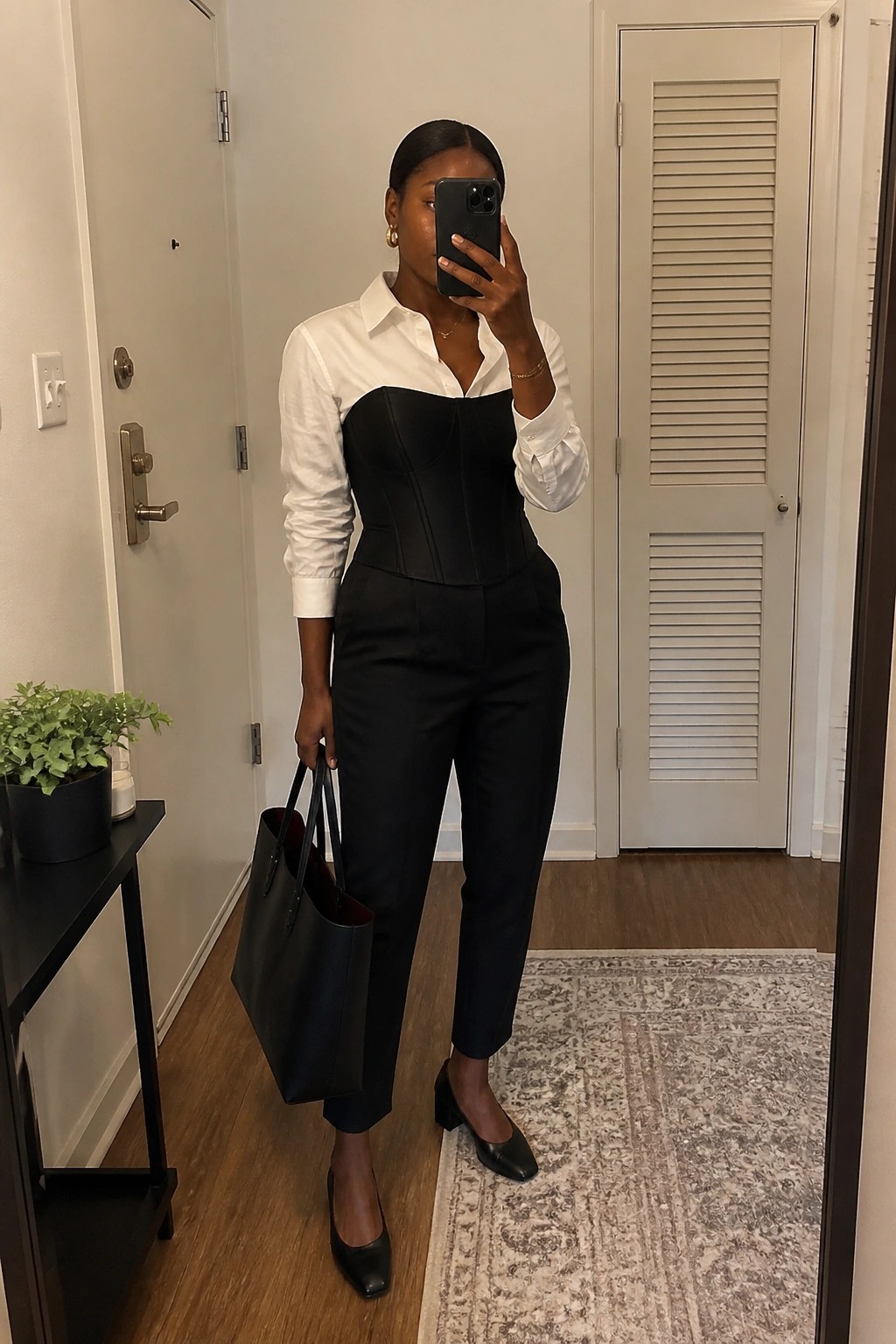 Woman in white shirt and black corset holding tote bag in hallway